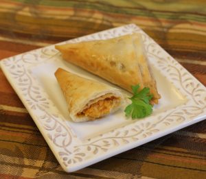 two sweet potato phyllo triangles on plate